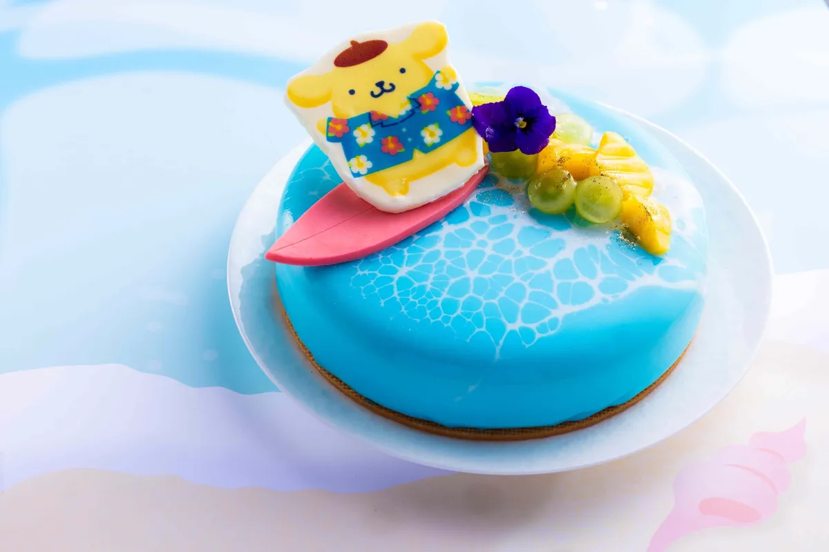 青い海をイメージしたケーキの上でサーフィンをするポムポムプリン