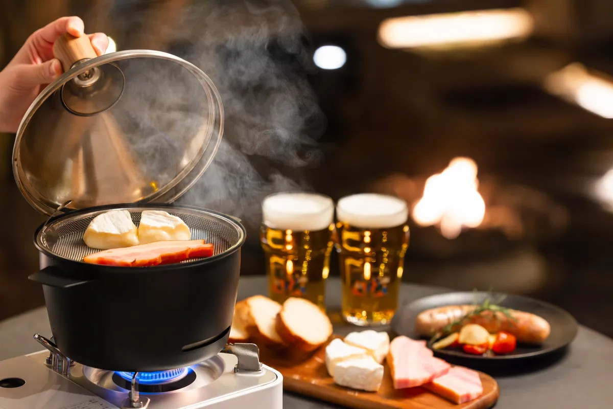 スモーククッカーから立ち上がる煙と美味しそうな燻製料理