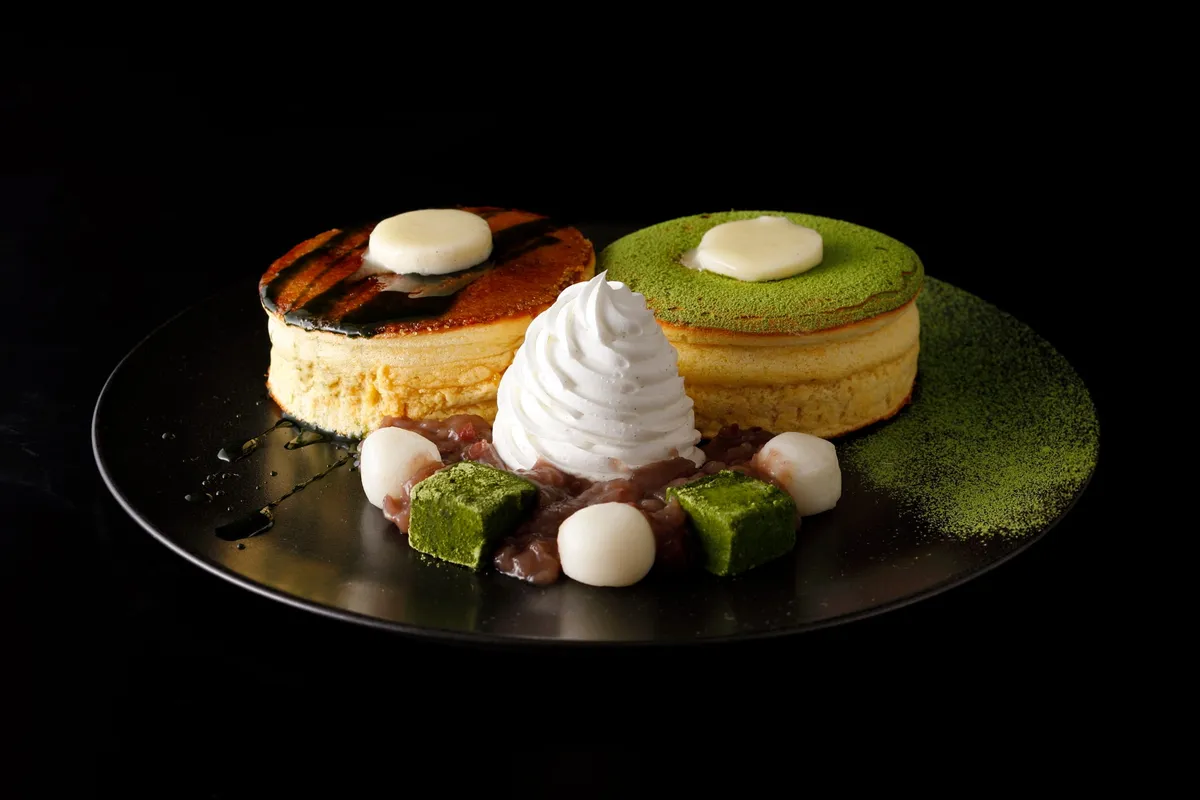 抹茶パウダーとクリームが添えられた厚焼きのパンケーキ