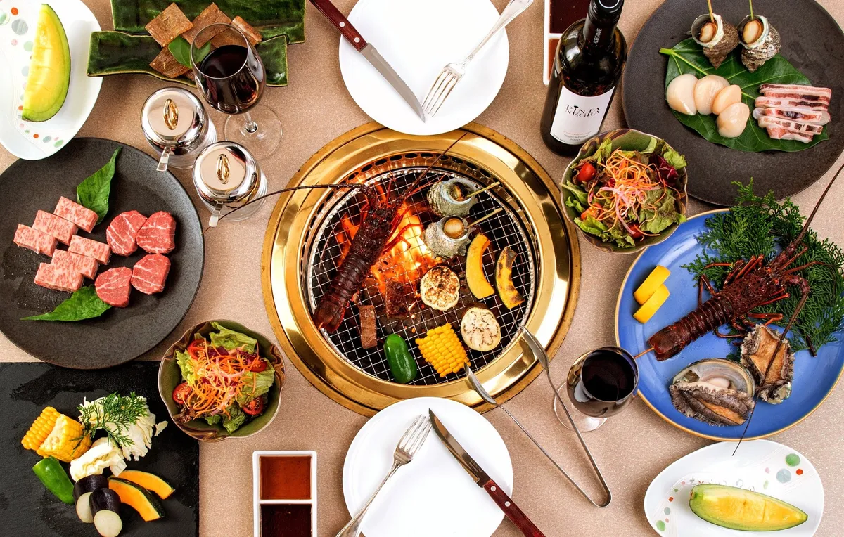伊勢海老やアワビ、霜降り肉が並ぶ豪華なBBQセットの俯瞰写真