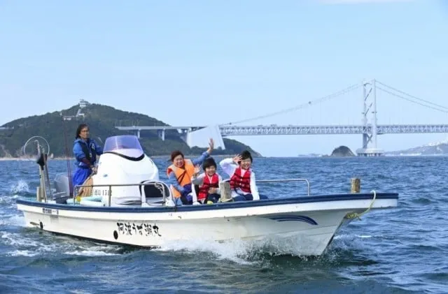 大鳴門橋に向かって進むクルージングを楽しむ家族