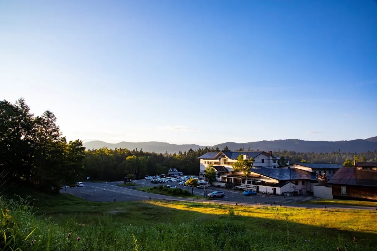 夕暮れ時に輝く休暇村乗鞍高原の外観と自然豊かな風景