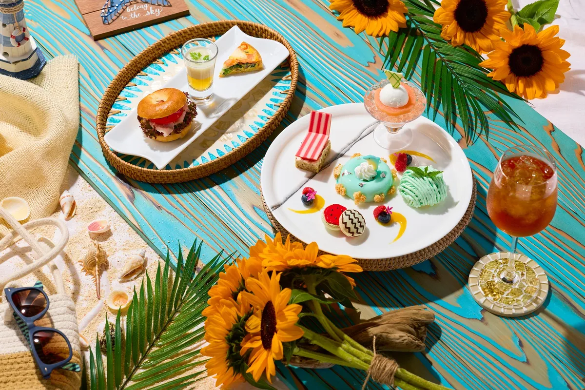 サマーバケーションアフタヌーンティーの全景。ひまわりや貝殻が添えられ夏らしい雰囲気