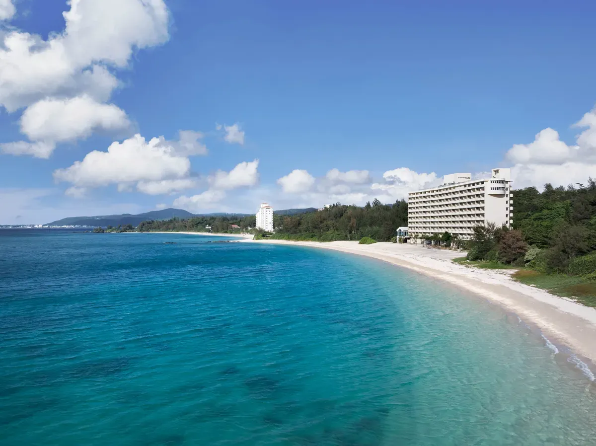 エメラルドグリーンの名護湾を望むホテルの全景