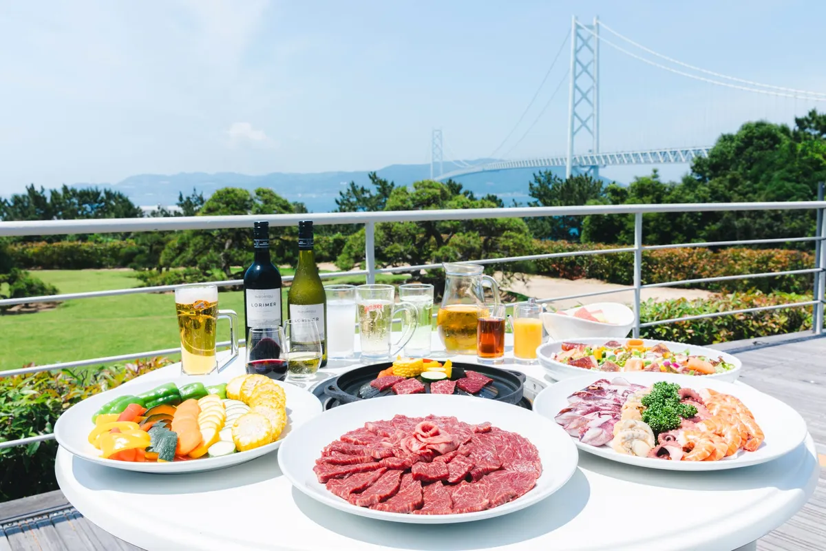 テラス席に並ぶ豪華なバーベキュー料理とドリンク