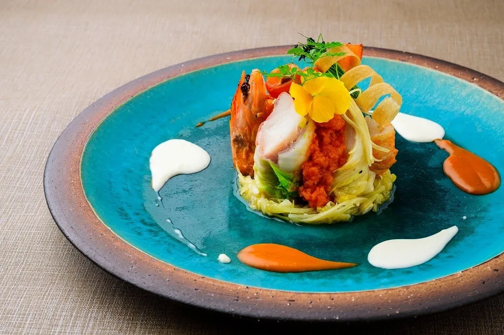 エメラルドグリーンの皿が海を彷彿とさせる魚料理