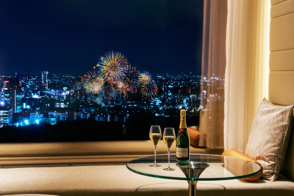 煌めく夜景と花火を背景にしたシャンパン