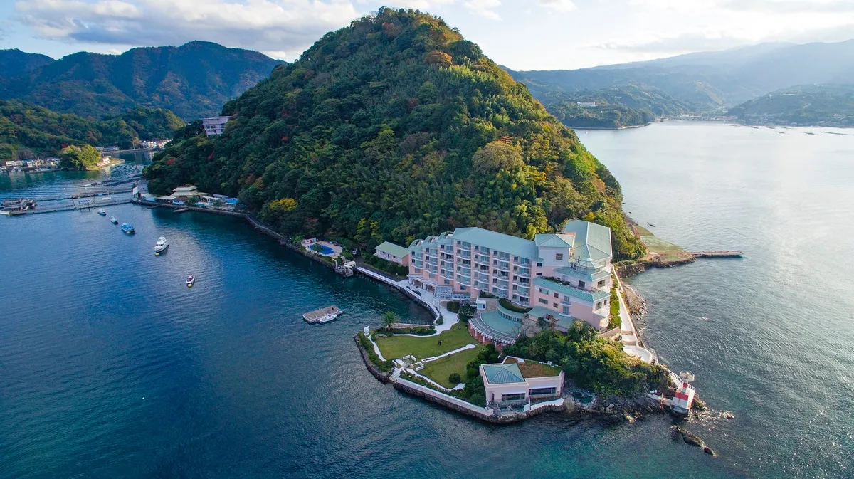 駿河湾に浮かぶ緑豊かな淡島とそこに佇むホテルの全景