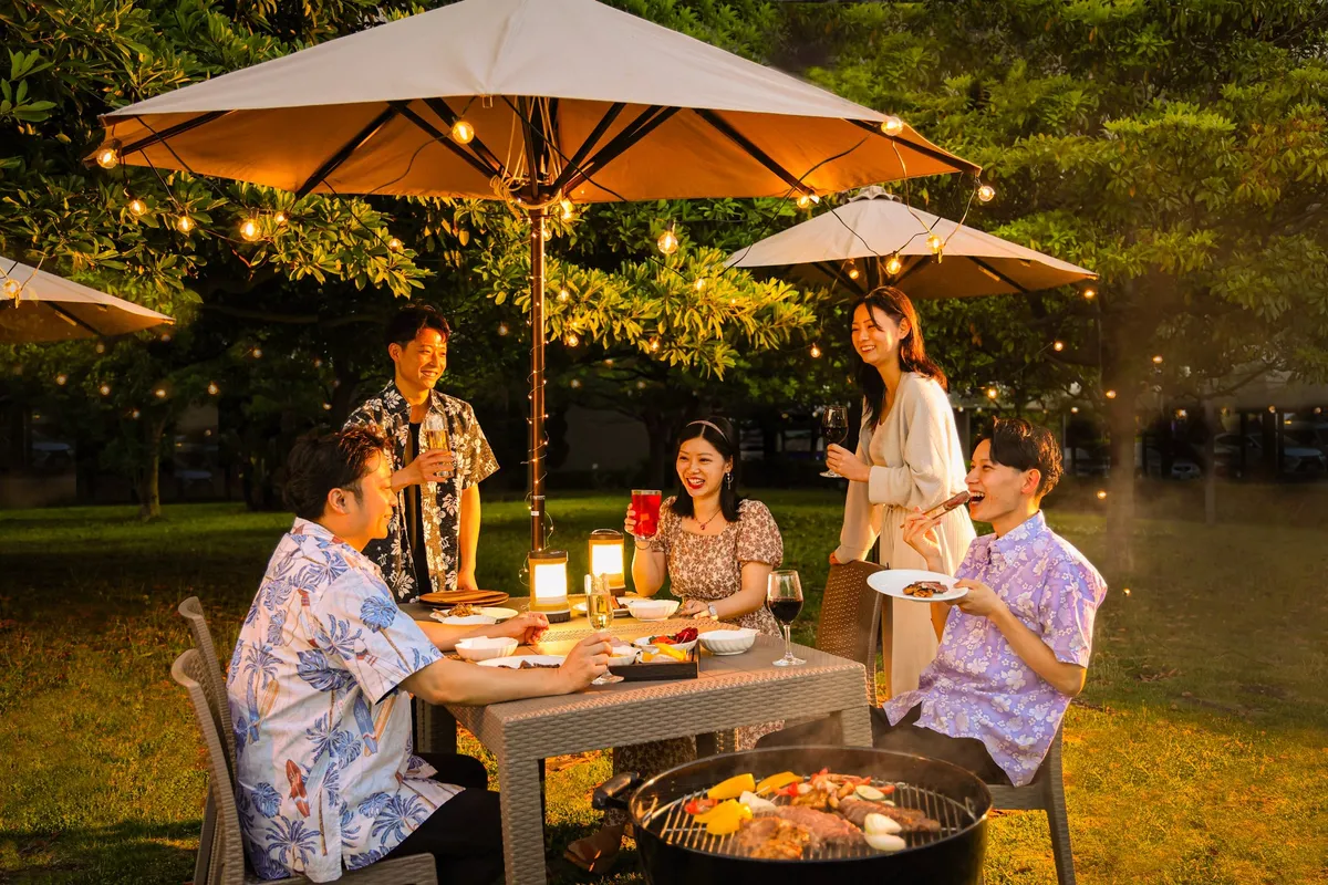 パラソルの下でBBQを楽しむグループ