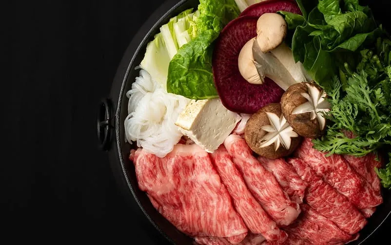 すき焼「おいし」で提供される色鮮やかな和牛と新鮮な野菜の盛り合わせ