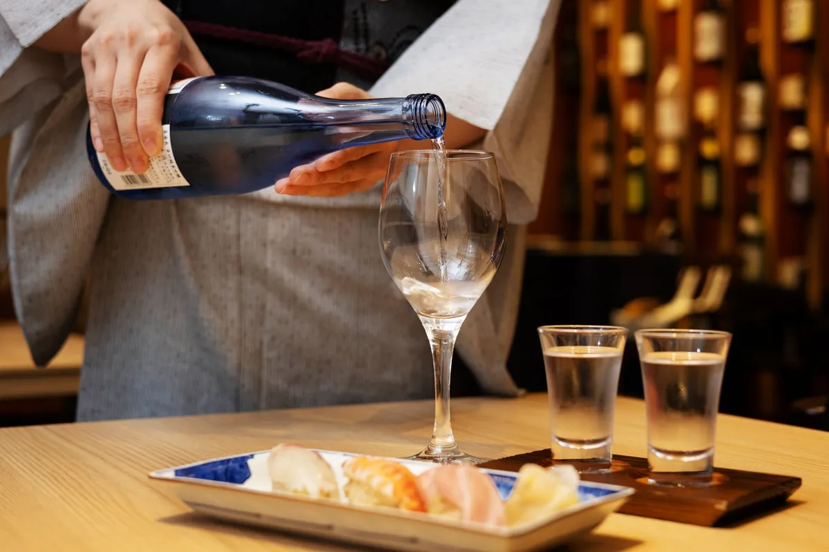 グラスに注がれる日本酒と鮨のペアリングイメージ