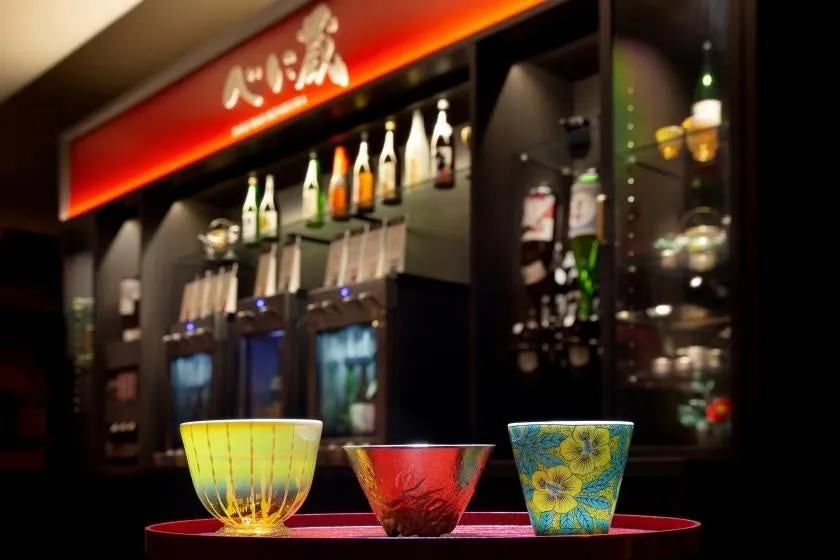 カウンターに並ぶ地酒のボトルとお洒落な酒器